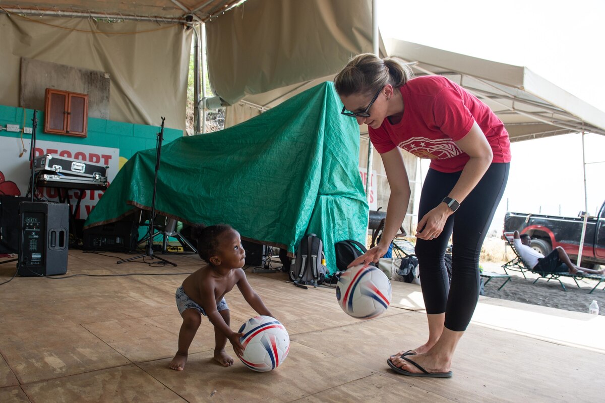 A woman plays with a toddler.