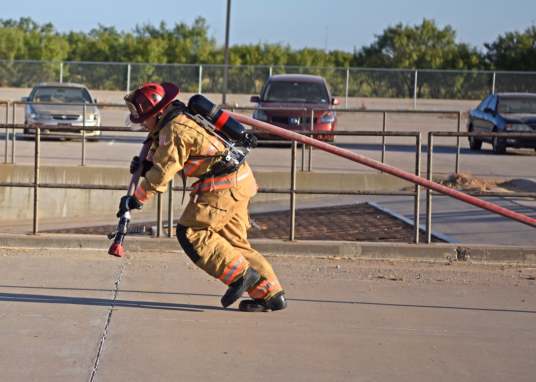 U.S. Air Force Tech. Sgt. Jordan Herrick, 312th Training Squadron instructor, drags a hose in full firefighting gear during the solo challenge at Blood, Sweat, and Stairs at the Louis F. Garland Department of Defense Fire Academy on Goodfellow Air Force Base, Texas, Oct. 5, 2019. During the solo challenge firefighters had to move heavy equipment and climb ladders as fast as possible. (U.S. Air Force photo by Airman 1st Class Ethan Sherwood/Released)