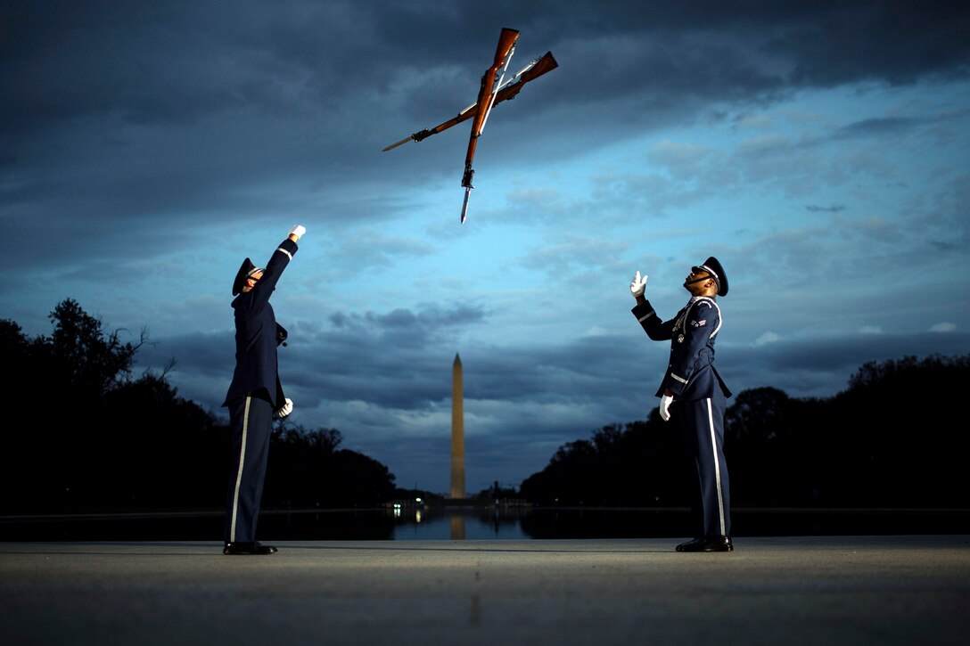Two airman throw their weapons at each other.