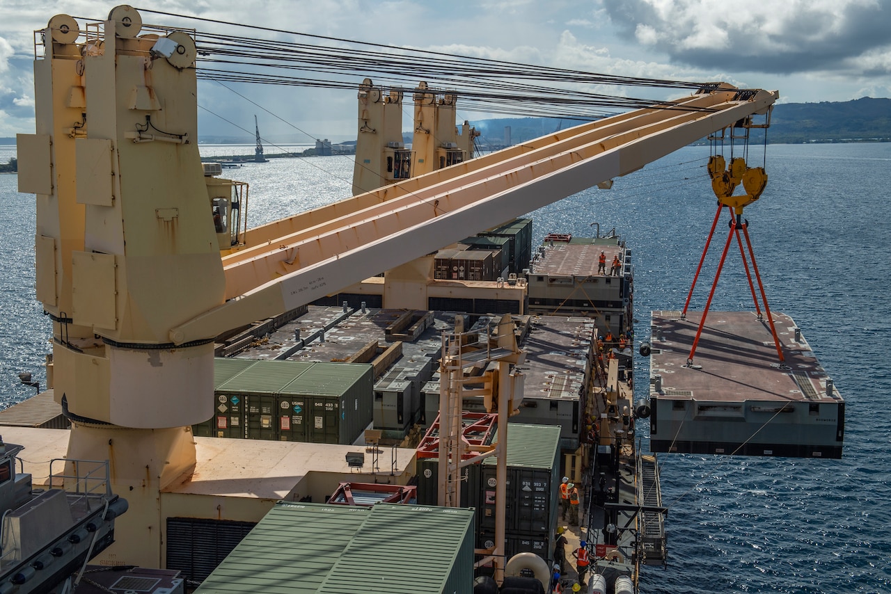 A large cargo crane moves a container from a ship.