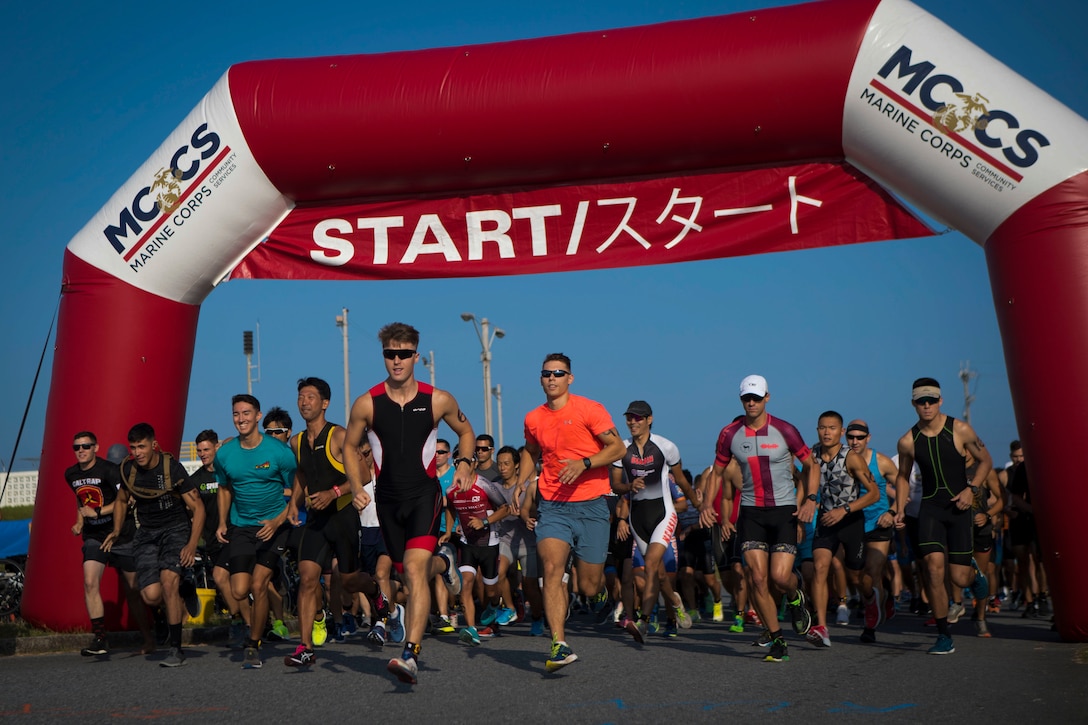 Runners consisting members of the U.S. and local communities begin the running portion of the 2019 Futenma Triathlon on Marine Corps Air Station Futenma, Okinawa, Japan, Oct. 6, 2019. The triathlon is held in order to strengthen the relationship between U.S service members and residents of Okinawa through athletic events. (U.S. Marine Corps photo by Cpl. Samuel Brusseau