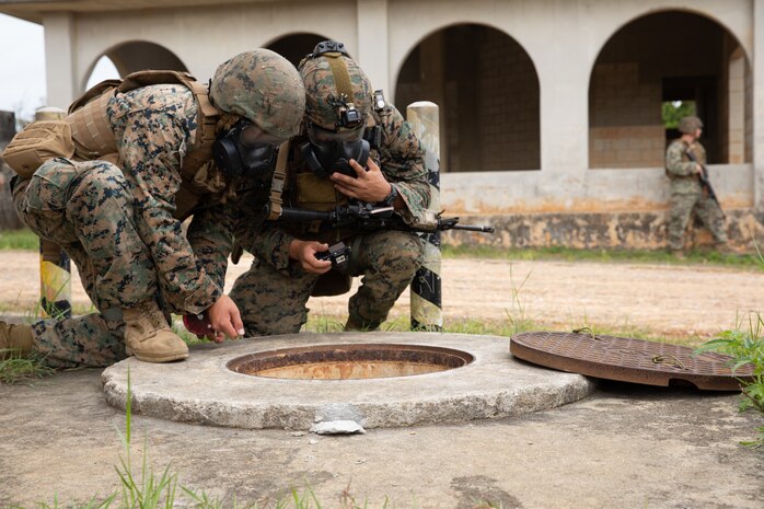 U.S. Marine Corps Cpl. Kyle Wielkie and Sgt. Jonathan Whitby lower atmospheric and chemical agent detectors into a storm drain to check for toxic or hazardous conditions during an explosive ordnance disposal exercise at Camp Hansen, Okinawa, Japan, Sept. 18, 2019. The EODEX was designed to simulate conventional warfare and the use of conventional ordnance and involved the participation of three U.S. military branches and over 43 different military occupational specialties within III Marine Expeditionary Force. Wielkie, a native of Lexington, South Carolina, is a chemical, biological, radiological and nuclear defense specialist with CBRN Defense Platoon, Headquarters Company, Headquarters Battalion, 3rd Marine Division and Whitby, a native of Tempe, Arizona, is an EOD technician with EOD Company, 9th Engineer Support Battalion, 3rd Marine Logistics Group.