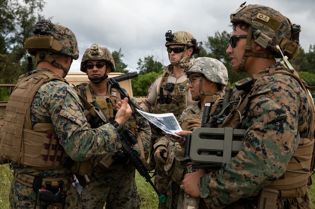 U.S. service members discuss a land mine scenario during an explosive ordnance disposal exercise at Kin Blue Training Area, Okinawa, Japan, Sept. 19, 2019.  The EODEX was designed to simulate conventional warfare and the use of conventional ordnance and involved the participation of three U.S. military branches and over 43 different military occupational specialties within III Marine Expeditionary Force.