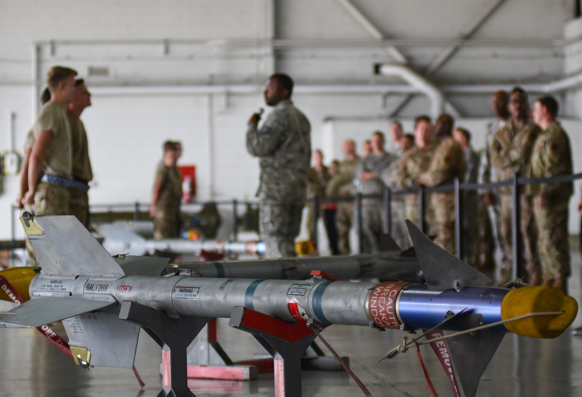 Weapons load crew members assigned to the 20th Aircraft Maintenance Squadron and spectators gather to watch a quarterly load crew competition at Shaw Air Force Base, South Carolina, Oct. 7, 2019.
