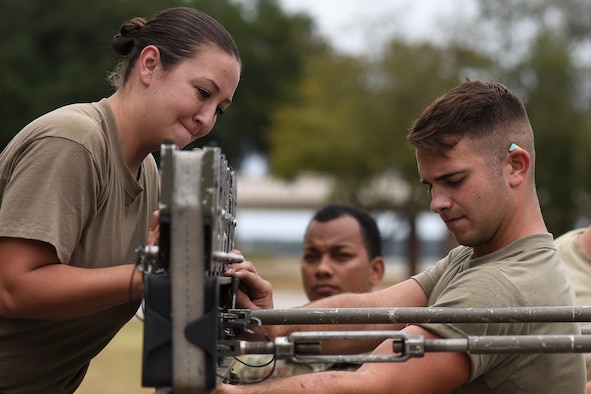 U.S. Air Force Staff Sgt. Demetrious Moutos, left, Senior Airman Josef Thompson, 77th Aircraft Maintenance Unit (AMU) load crew members work together to finish loading munitions on an F-16CM Viper during the quarterly load crew competition at Shaw Air Force Base, South Carolina, Oct. 7, 2019.