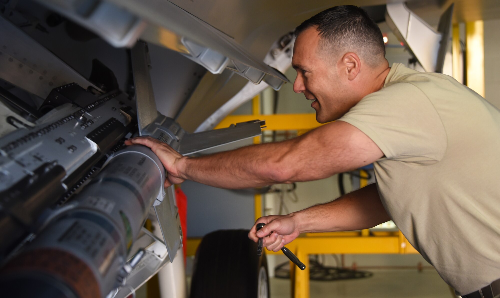 Armament apprentice course student, loads an AIM-9 into the side weapons bay of an F-22 at Sheppard Air Force Base