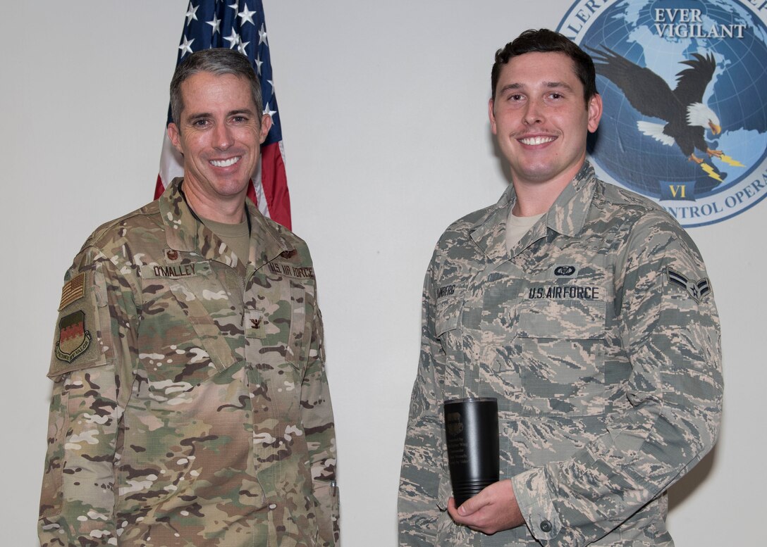 U.S. Air Force Col. Derek O’Malley, 20th Fighter Wing (FW) commander, left, recognized Airman 1st Class Preston Danberg, 20th FW Command Post junior emergency action controller, as Weasel of the Week (WOW) at Shaw Air Force Base, South Carolina, Oct. 3, 2019.