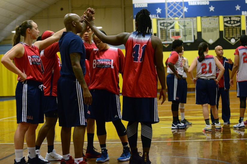 A women's basketball team put their hands together.