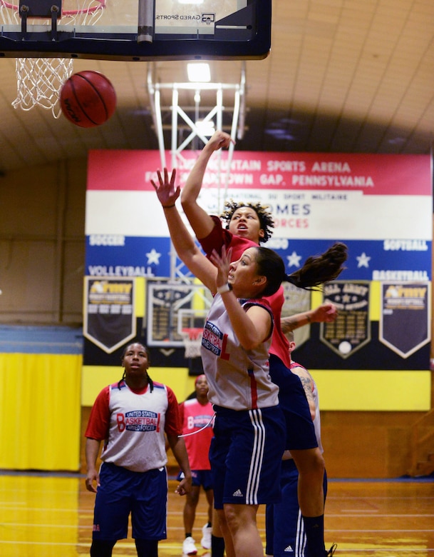 Women basketball players battle for a rebound.