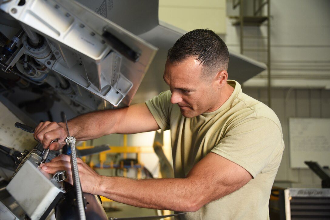 Armament apprentice course student, loads an AIM-9 into the side weapons bay of an F-22 at Sheppard Air Force Base