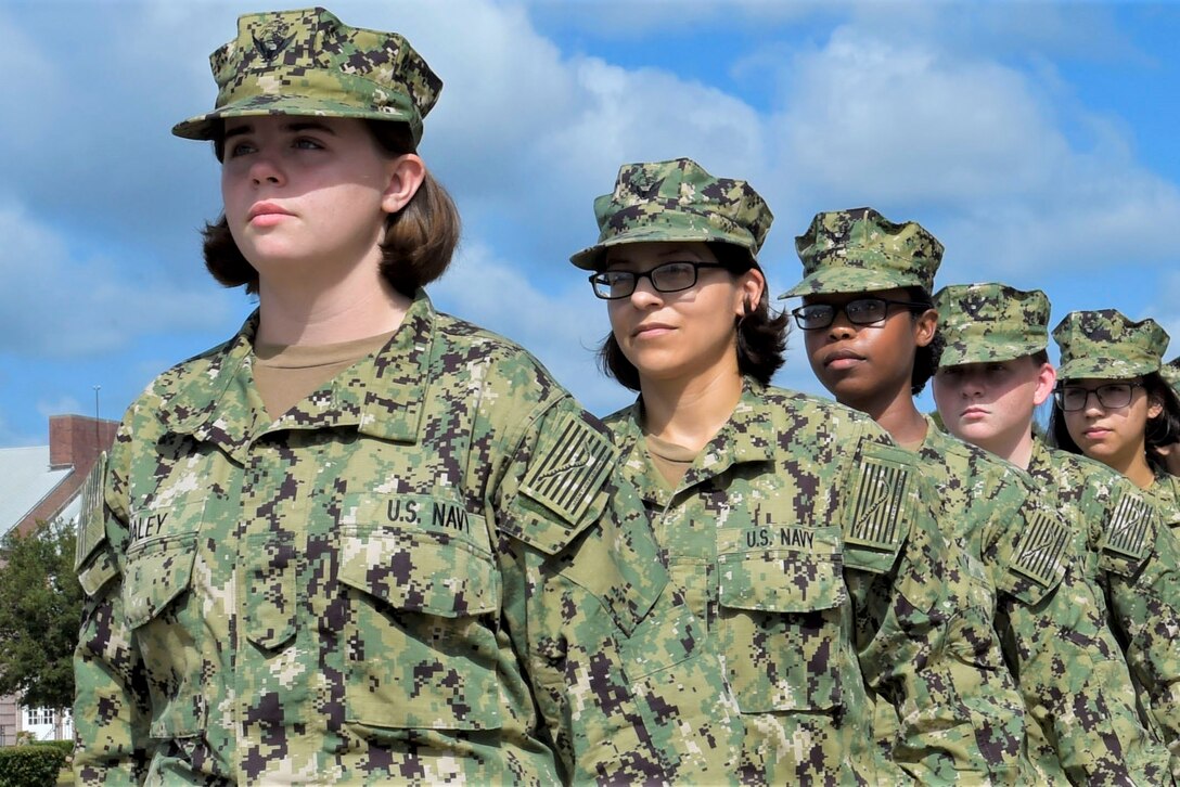 A group of sailors stand in a straight line.