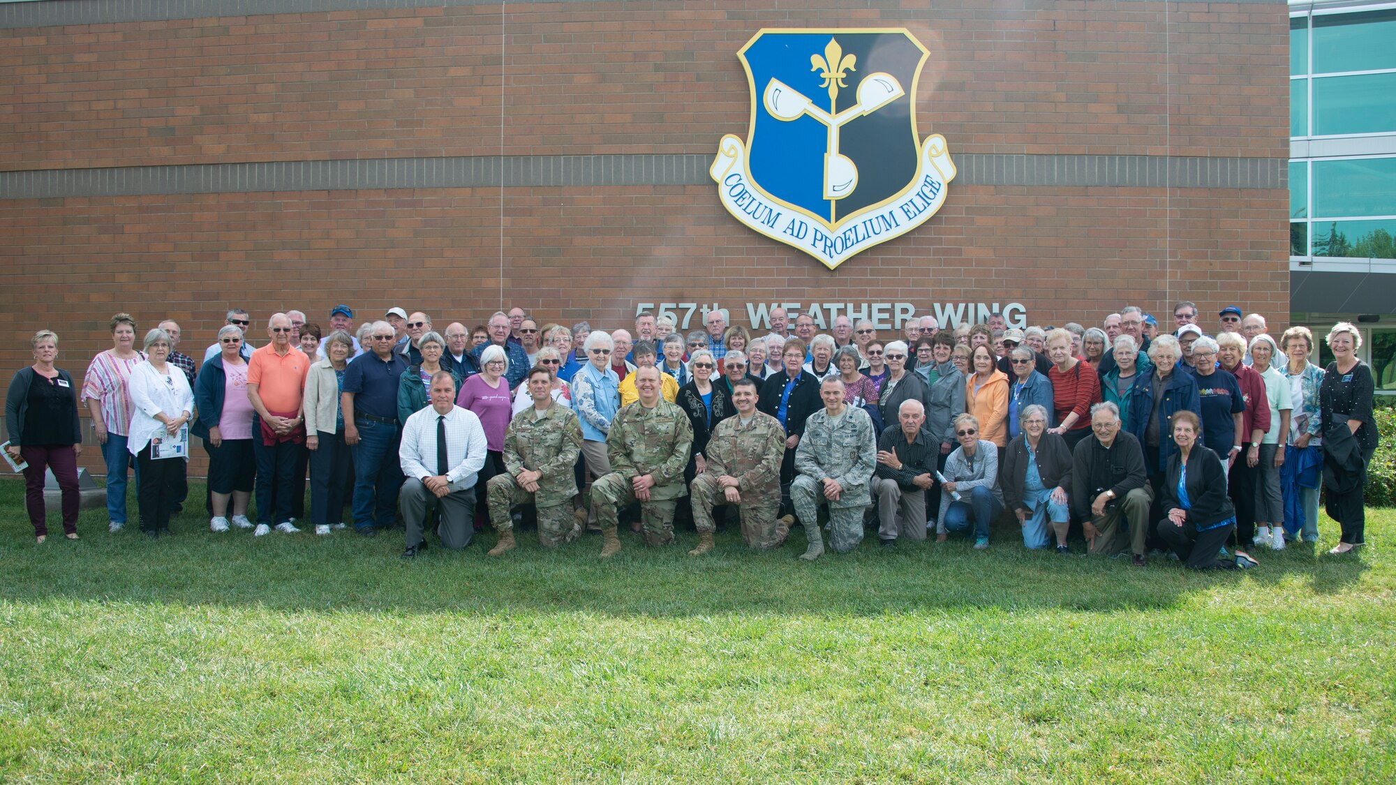 Visitors from Rochester, Minnesota, pose for a group photo with members of the 557th Weather Wing in front of the 557th WW headquarters building at Offutt Air Force Base, Nebraska, Sept. 19, 2019. Members of the group annually bake cookies for care packages sent to deployed service members. (U.S. Air Force photo by Paul Shirk)