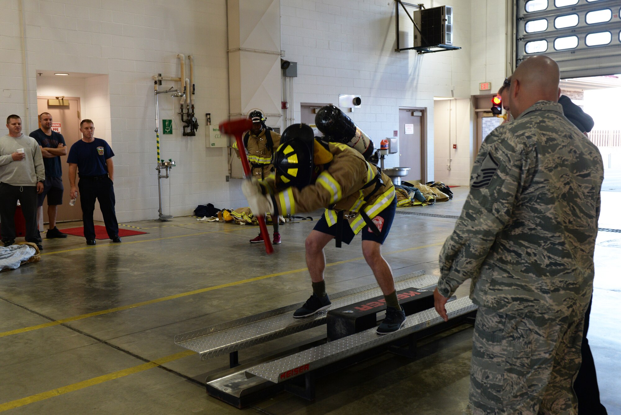An Airman hits a keiser sled during the Firefighter Challenge at the 28th Civil Engineer Squadron Fire Department at Ellsworth Air Force Base, S.D., Oct. 4, 2019. Hitting a keiser sled simulates trying to bust down drywall or a hard wall during a house fire. (U.S. Air Force photo by Airman Quentin K. Marx)