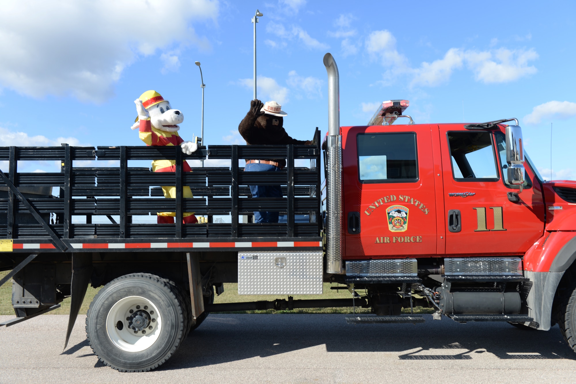 Sparky the Dalmatian and Smoky the Bear wave to children during the Fire Prevention Week Parade at the Prairie View housing area at Ellsworth Air Force Base, S.D., Oct. 5, 2019. Five fire trucks from the 28th Civil Engineer Squadron Fire Department drove through base housing during the parade and promoted Fire Prevention Week, which commemorates the “Great Chicago Fire” from 1871. (U.S. Air Force photo by Airman Quentin K. Marx)