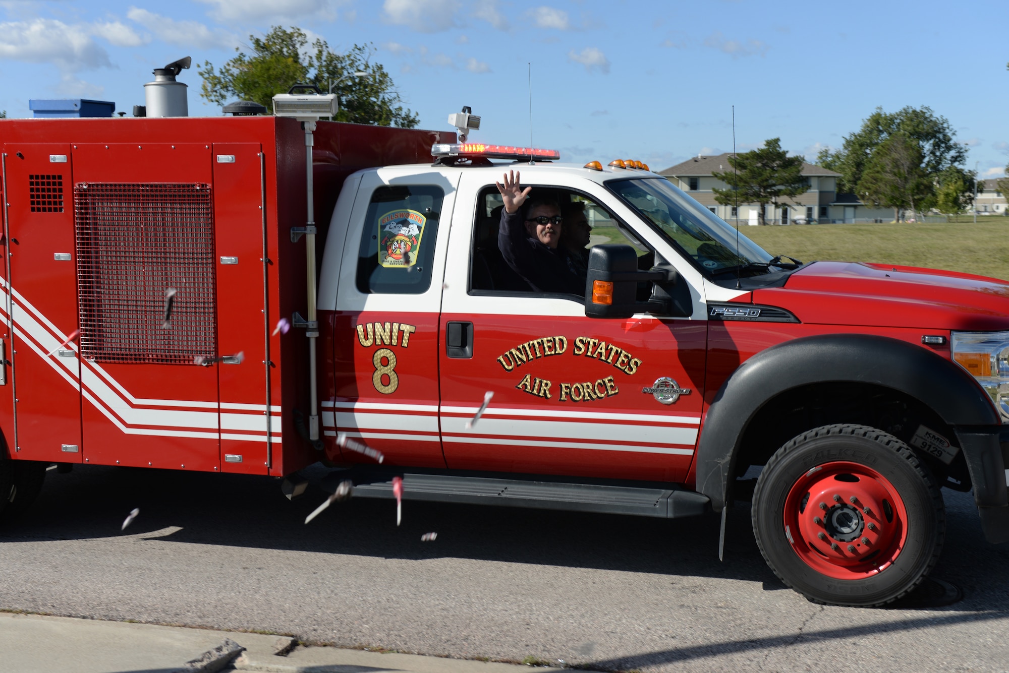 A firefighter throws candy during the Fire Prevention Week Parade at Ellsworth Air Force Base, S.D., Oct. 5, 2019.  Fire Prevention Week is observed each year during the week of Oct. 9, which commemorates the “Great Chicago Fire” from 1871, and is a time in which fire departments worldwide remind communities to take the appropriate measures and precautions to prevent fires. (U.S. Air Force photo by Airman Quentin K. Marx)