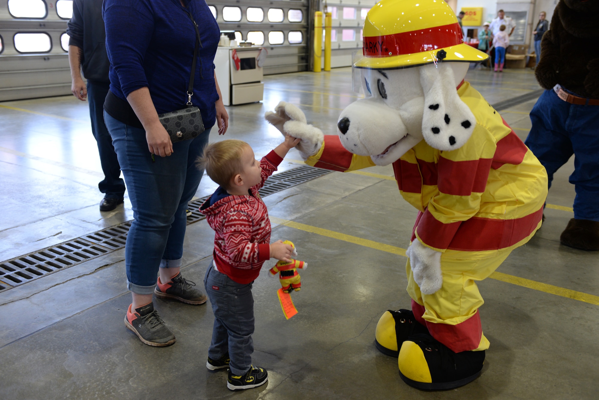 Sparky the Dalmatian high-fives a child during the Fire Prevention Week Open House event at the 28th Civil Engineer Squadron Fire Department at Ellsworth Air Force Base, S.D., Oct. 5, 2019. The Fire Department conducted an open house where children and families could interact with Sparky and learn fire safety. (U.S. Air Force photo by Airman Quentin K. Marx)