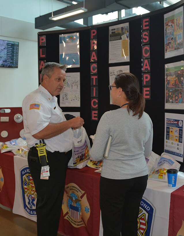 Assistant fire chief speaks with employee about fire prevention