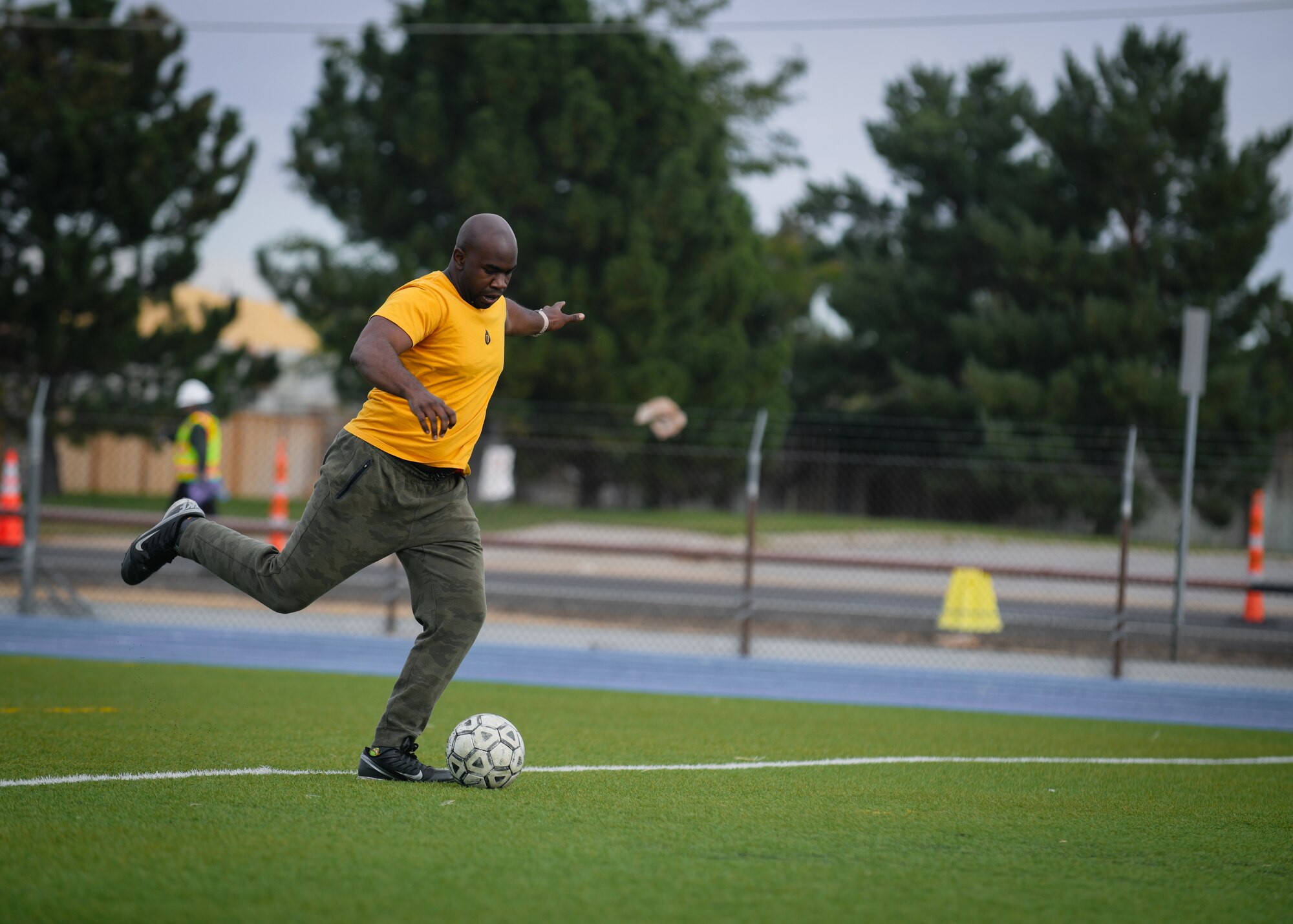 Senior Airman Bakari Robinson, a 460th Civil Engineer Squadron water fuel maintainer, kicks a soccer ball at the track on Buckley Air Force Base, Colo.