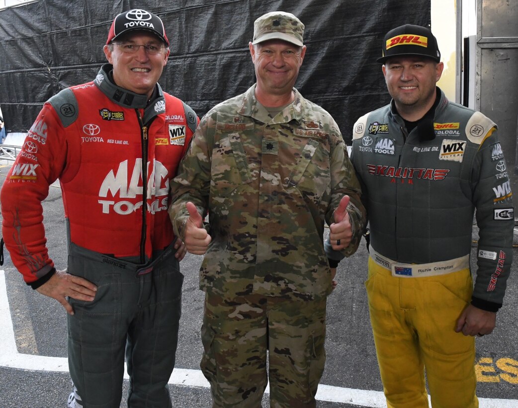 The National Hot Rod Association held their Midwest Nationals at the World Wide Technology Raceway at Gateway Motorsports, Madison Illinois, with Lt. Col. William McLeod, 932nd Maintenance Group commander, invited to help start the event as an honored guest, Sept. 29, 2019.  At left, Doug Kalitta is an American auto racing driver from Michigan and owner of the airline Kalitta Charters. Kalitta formerly raced in USAC events. He was the 1991 USAC rookie of the year in the midget series, and won the 1994 championship in the sprint car category while last year he won the season opener in Pomona, 
reached five final rounds, and  qualified for the NHRA Countdown to the Championship for the 11th year in a row.  At far right, driver Ritchie Crampton has 10 Career Wins, 12 Career Final Rounds and 329.91 miles per hour Career Best Speed.  Col. McLeod was brought on stage during the opening ceremony and presented an NHRA challenge coin, and waved to the cheering crowd.  (U.S. Air Force photo by Lt. Col. Stan Paregien)