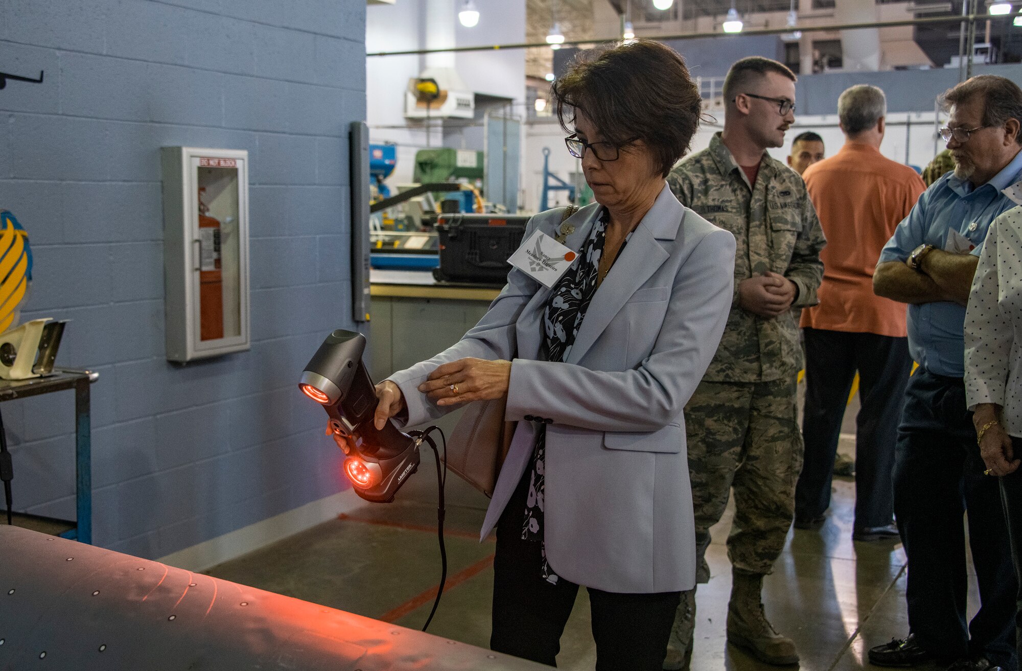 Nancy Meadow-Trigueiro, left, McNaughton Media uses a 3D hand scanner during the 60th Maintenance Group Honorary Commanders tour, Oct. 4th, 2019, at Travis Air Force Base, California.  The purpose of the Honorary Commanders Program is to promote relationships between base senior leadership and civilian partners, foster civic appreciation of the Air Force mission and its Airmen, maximize opportunities to share the Air Force story with new stewards and to communicate mutual interest, challenges and concerns senior leaders and civilian stakeholders have in common. (U.S. Air Force photo by Heide Couch)