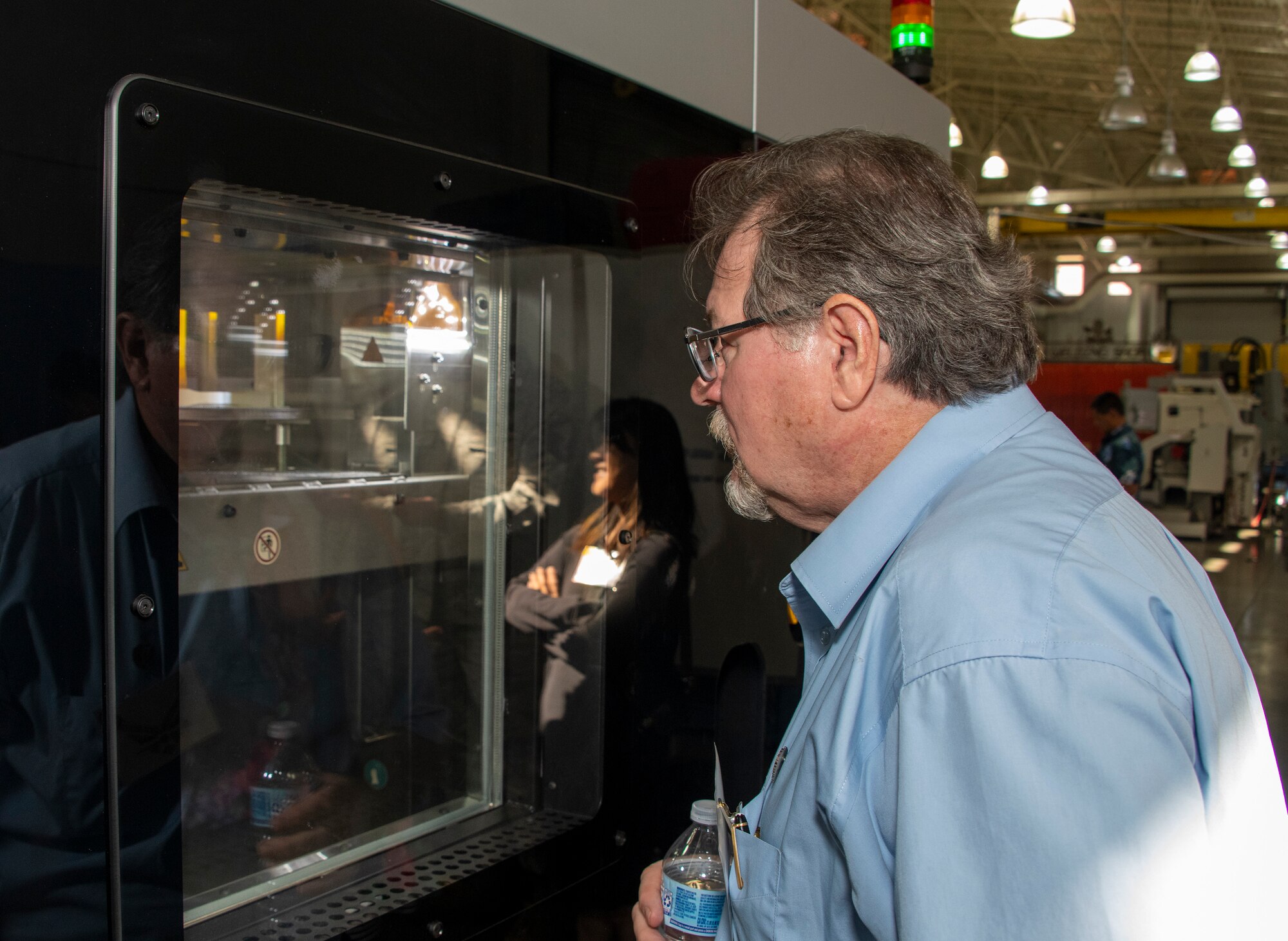 Rick Novosad, Robert Mondavi Winery, and Honorary Commander for the 821st Contingency Response Squadron, watches a 3D printer at work at the sheet metal shop during the 60th Maintenance Group Honorary Commanders tour, Oct. 4th, 2019, at Travis Air force Base, California.  The purpose of the Honorary Commanders Program is to promote relationships between base senior leadership and civilian partners, foster civic appreciation of the Air Force mission and its Airmen, maximize opportunities to share the Air Force story with new stewards and to communicate mutual interest, challenges and concerns senior leaders and civilian stakeholders have in common. (U.S. Air Force photo by Heide Couch)
