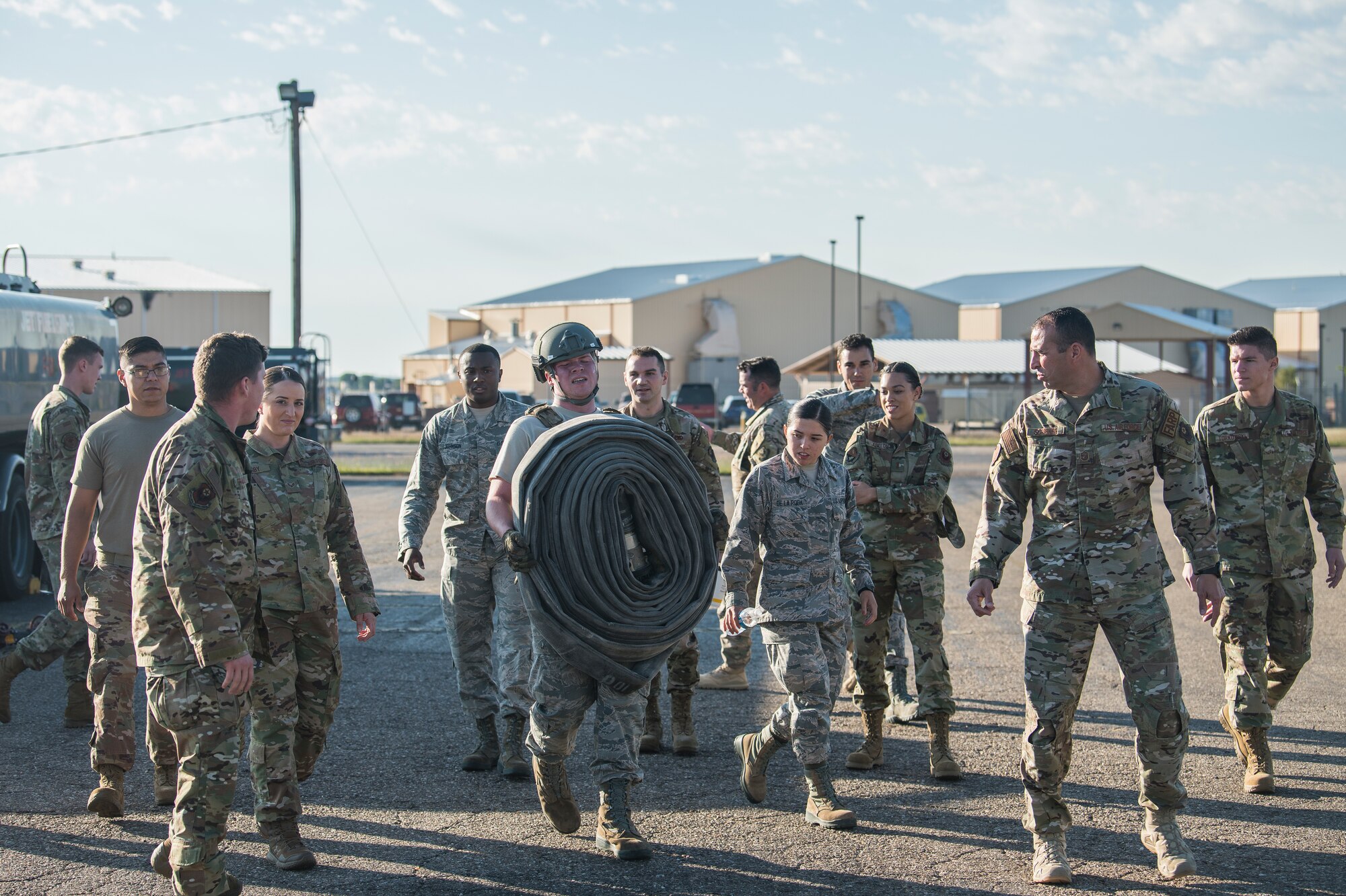 Airman 1st Class Kyle Fabrizius, 27th Special Operations Logistics Readiness Squadron fuels distribution technician, carries a fuel hose while members of the 27 SOLRS watch and cheer him on during the Forward Air Refueling Point tryouts at Cannon Air Force Base, N.M., October 9, 2019. The hose carry is the final part of the tryout, where members have to carry a 100 pound hose as fast as they can. (U.S. Air Force photo by Senior Airman Vernon R. Walter III)