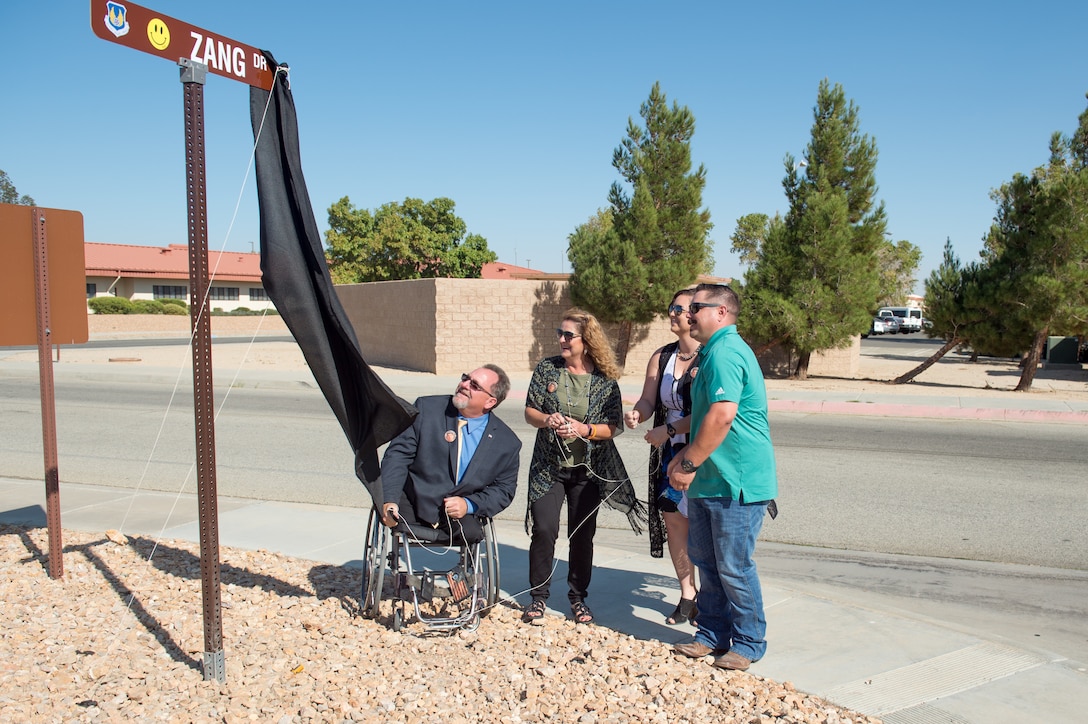 Dan Osburn, 412th Test Wing Technical Director, and members of the Zang family unveil the newly-dedicated Zang Drive road sign during a ceremony at Edwards Air Force Base, Oct. 9. The road was renamed in honor of Patrick Zang, an Edwards test engineer who passed away last year. Zang’s career spanned more than 30 years and is the first Air Force civilian to have a road dedicated in his memory. (U.S. Air Force photo by Richard Gonzales)