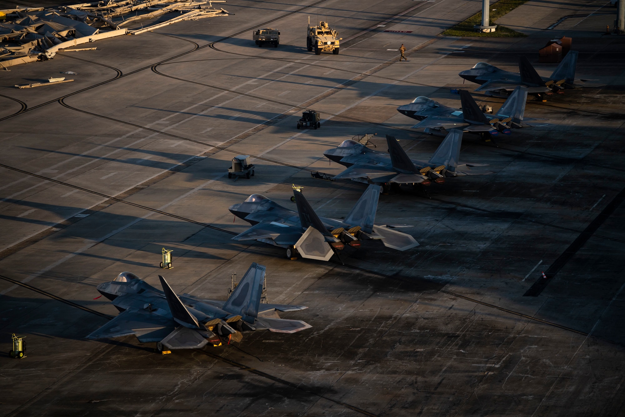 F-22 Raptors are parked near the runway at Tyndall Air Force Base, Florida, Oct. 15, 2018. Air Combat Command has mobilized multiple relief assets in an effort to restore operations after the hurricane caused catastrophic damage to the base. (U.S. Air Force photo by Master Sgt. Russ Scalf)