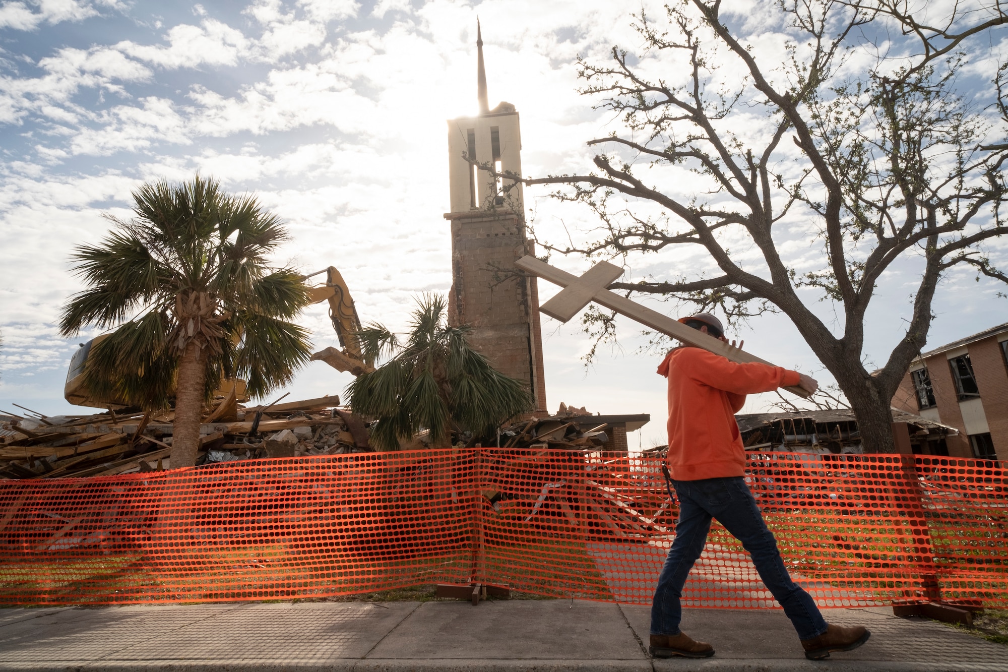 Kylan Nathey, a field operations manager, carries a cross from Chapel 2 at Tyndall Air Force Base, Fla., Feb. 15, 2019. The chapel was severely damaged by Hurricane Michael, a category 4 storm that made landfall on Oct. 10, 2018. The demolition marked the beginning of a long process to clear out damaged structures to make way for new construction. (U.S. Air Force photo by Senior Airman Javier Alvarez)