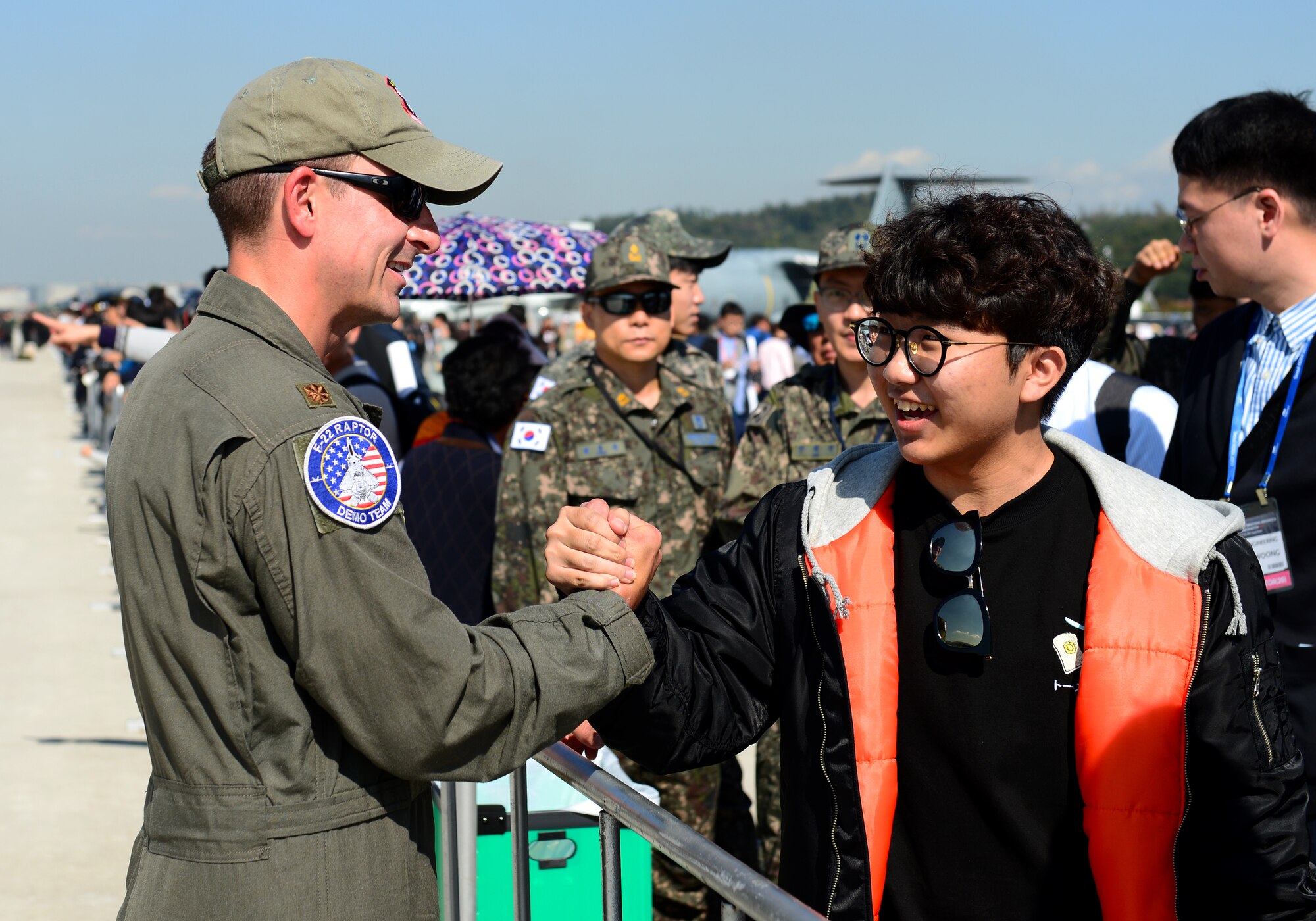 U.S. Air Force Maj. Dan “Rock” Dickinson, Air Combat Command F-22 Raptor Demonstration Team pilot, shakes the hand of an enthusiastic fan after his performance at the Seoul International Aerospace and Defense Exhibition 2017 at the Seoul Airport, Republic of Korea, Oct. 20, 2017. The Seoul ADEX is the largest, most comprehensive event of its kind in Northeast Asia, attracting aviation and aerospace professionals, key defense personnel, aviation enthusiasts and the general public alike. (U.S. Air Force photo by Staff Sgt. Alex Fox Echols III)