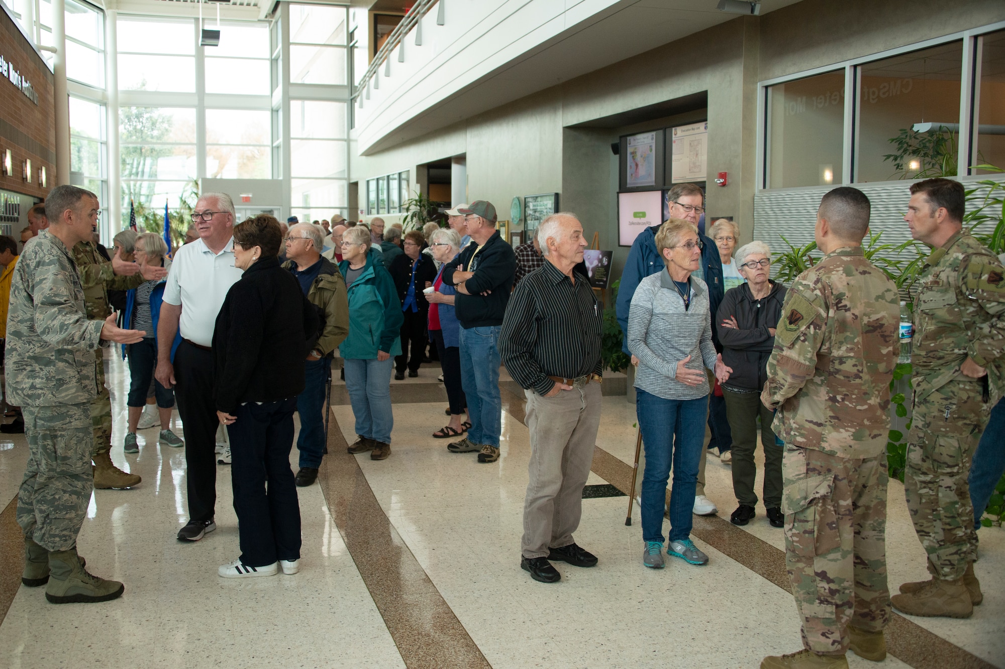 Visitors from Rochester, Minnesota, speak with Airmen in the 557th Weather Wing’s atrium at Offutt Air Force Base, Nebraska, Sept. 19, 2019. The visit to Offutt AFB was a surprise as part of a three day mystery tour. (U.S. Air Force photo by Paul Shirk)
