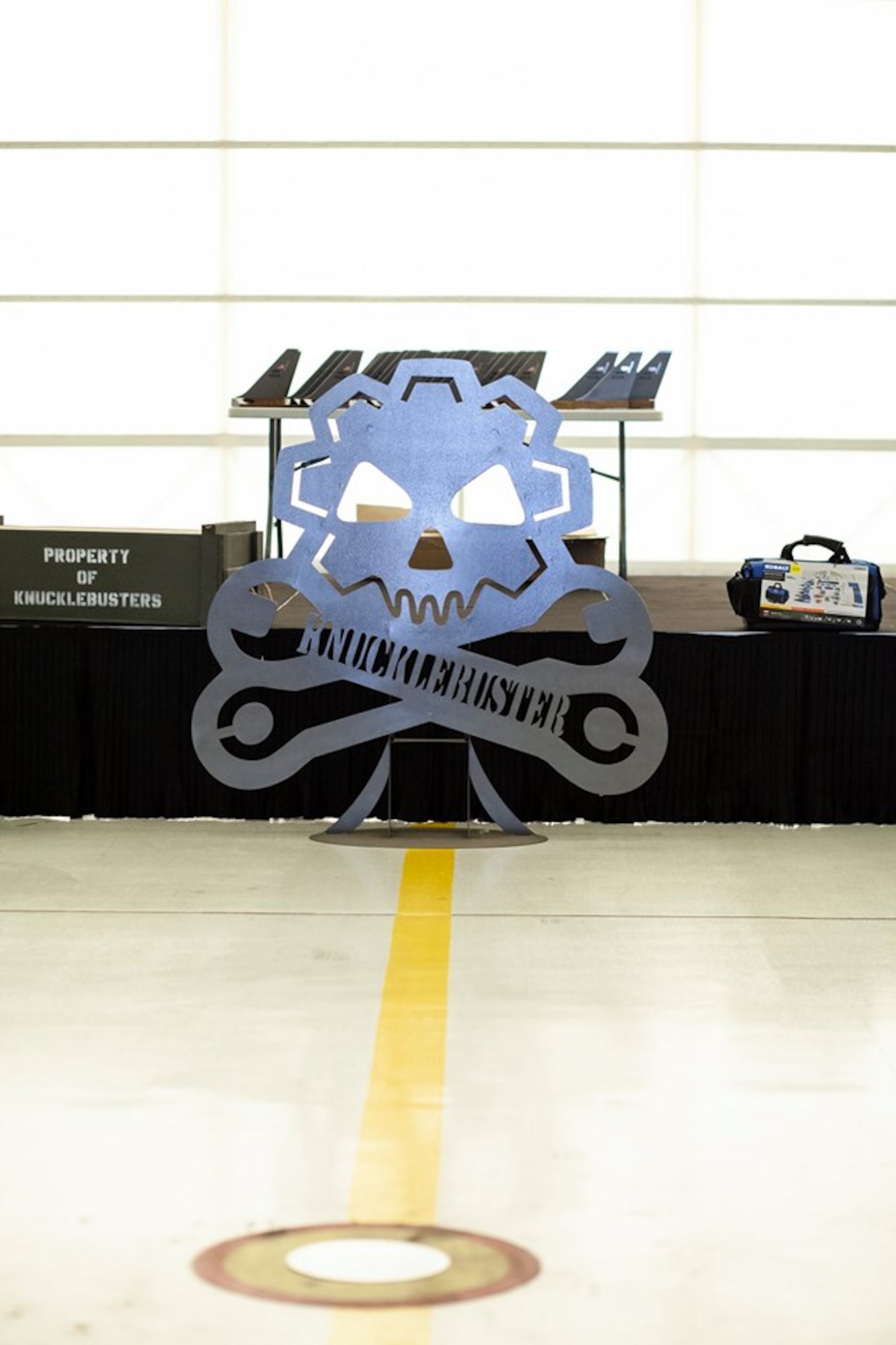 The Knucklebuster insignia stands in front of the stage at the Knucklebuster’s Award Ceremony Oct. 5, 2019, at McConnell Air Force Base, Kan. The banquet is held annually to recognize maintainers who have significantly impacted their squadron’s mission. (U.S. Air Force photo by 2nd Lt. Kaitlyn Danner)