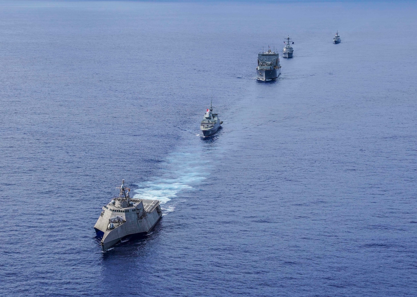 WATERS NEAR GUAM (Sept. 30, 2019) The littoral combat ship USS Gabrielle Giffords (LCS 10) leads a formation followed by Republic of Singapore Navy (RSN) frigate RSS Formidable (FFS 68), dry cargo ship USNS Amelia Earhart (T-AKE 6), guided-missile destroyer USS Momsen (DDG 92), and RSN frigate RSS Intrepid (FFS 69) during a photo exercise (PHOTOEX) in support of Exercise Pacific Griffin 2019. Pacific Griffin is a biennial exercise conducted in the waters near Guam aimed at enhancing combined proficiency at sea while strengthening relationships between the U.S. and Republic of Singapore navies.