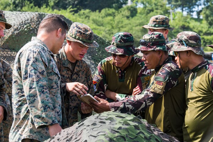 U.S. Marines and Philippine Airmen compare different methods on how to set up a range card during a subject matter expert exchange as part of exercise KAMANDAG 3 at Colonel Ernesto P. Ravina Air Base, Philippines, Oct. 9.