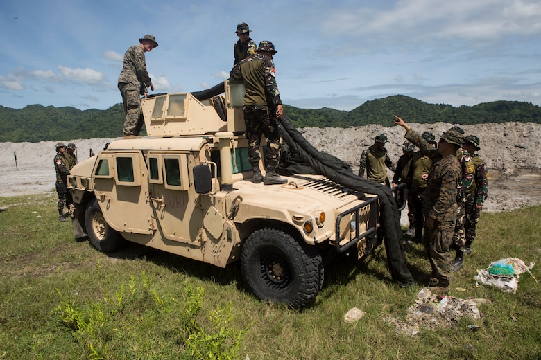 U.S. Marines and Philippine Airmen perform a practical application of setting up a team position during a subject matter expert exchange as part of exercise KAMANDAG 3 at Colonel Ernesto P. Ravina Air Base, Philippines, Oct. 9.