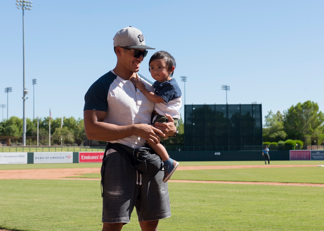 Staff Sgt. Joseluis Guerra, 56th Security Forces Squadron noncommissioned officer in charge of armory, and his son are recognized during a Major League Baseball Arizona Fall League game Oct. 6, 2019, at Camelback Ranch stadium in Phoenix.