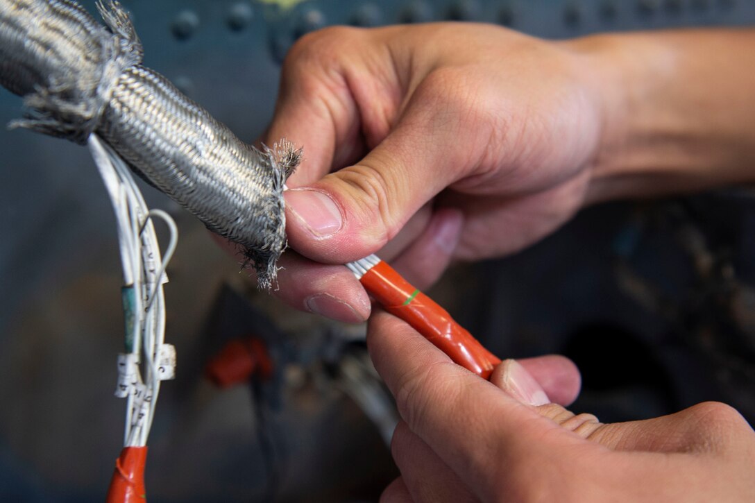 An Airman assigned to the 23d Maintenance Group (MXG) puts F4 Tape on wires within a cable harness during an HH-60G Pave Hawk phase inspection Oct. 9, 2019, at Moody Air Force Base, Ga. The 23d MXG maintainers disassemble, inspect and repair the HH-60 after every 600 flight hours. These maintainers continually work to ensure the aircraft are safe and reliable for search and rescue missions. (U.S. Air Force photo by Airman Azaria E. Foster)