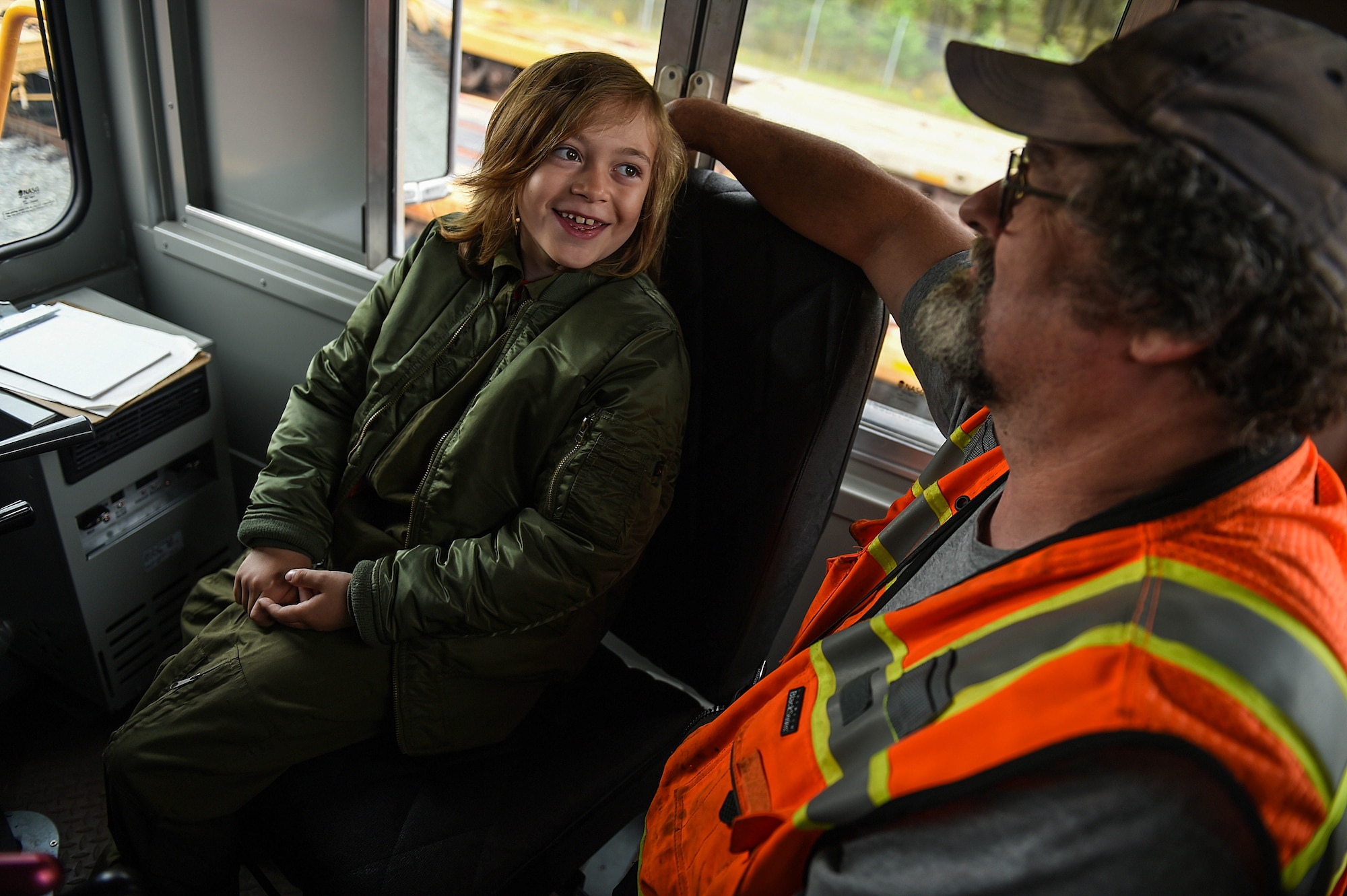 Declan Gaskill, Joint Base Lewis-McChord (JBLM) Pilot for a Day (PFAD) participant, talks with Bud Brown, JBLM train depot locomotive engineer, inside a train engine to receive instruction before driving a short distance down some tracks May 21, 2019. Declan had a big interest in trains so the PFAD itinerary organizer reached out to the train depot to see if they could be included in his day to make it extra special.