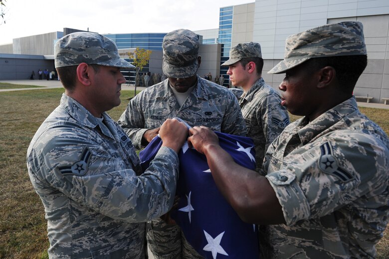 Members of the National Air and Space Intelligence Center, Global Exploitation Intelligence Group fold the flag during a Retreat Ceremony on Oct. 1, 2019 at Wright-Patterson Air Force Base, Ohio. A Retreat Ceremony serves a twofold purpose. It signals the end of the official duty day and serves as a ceremony for paying respect to the flag.