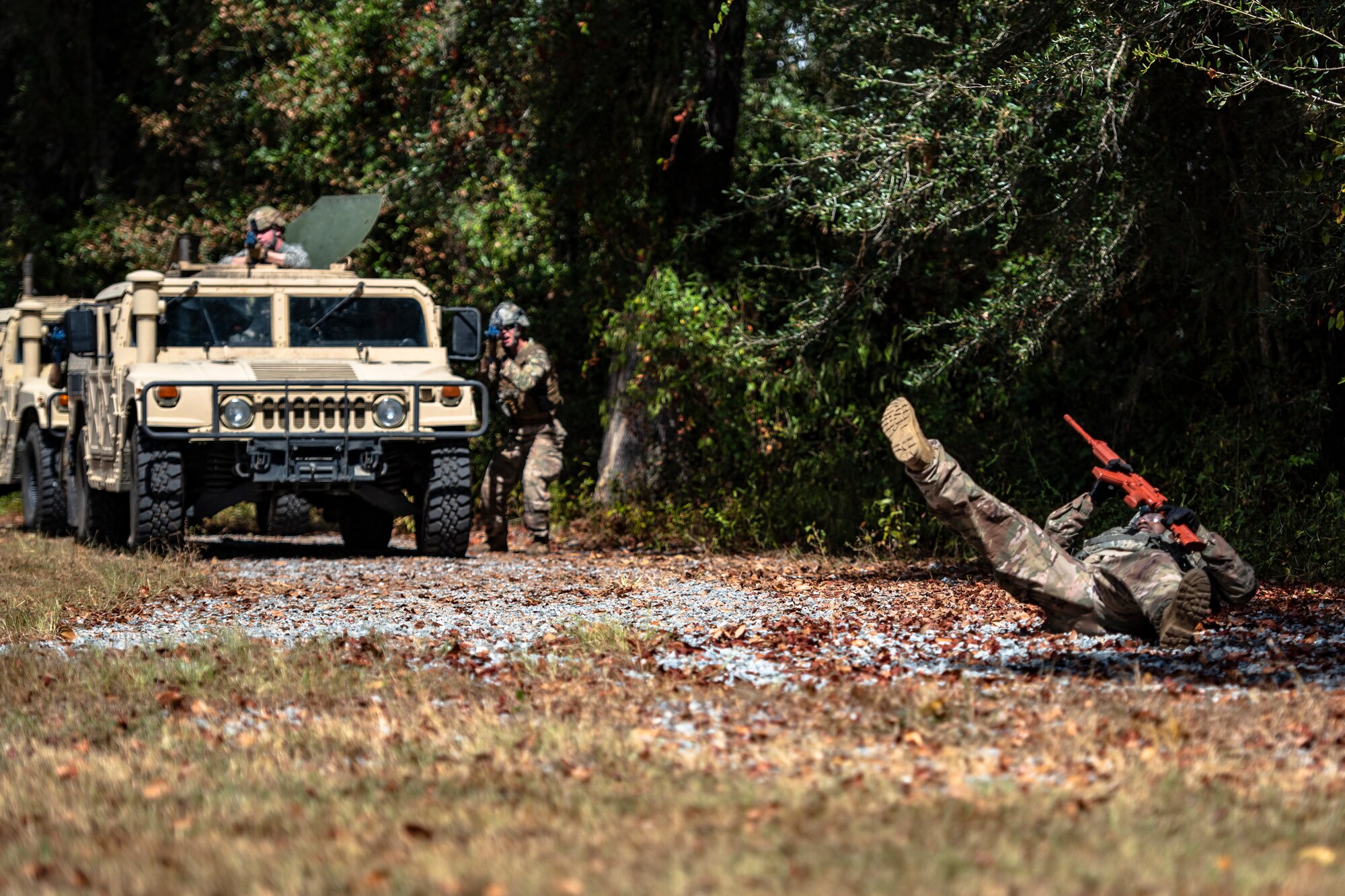 A simulated casualty, right, falls to the ground during a field convoy operation Oct. 8, 2019, at Moody Air Force Base, Ga. The field convoy operation gave 23d Security Forces Squadron Airmen an opportunity to improve the ability to shoot, move and communicate, ensuring the Airmen are properly trained and prepared to carry out their mission in a contested environment. (U.S. Air Force photo by Airman 1st Class Taryn Butler)