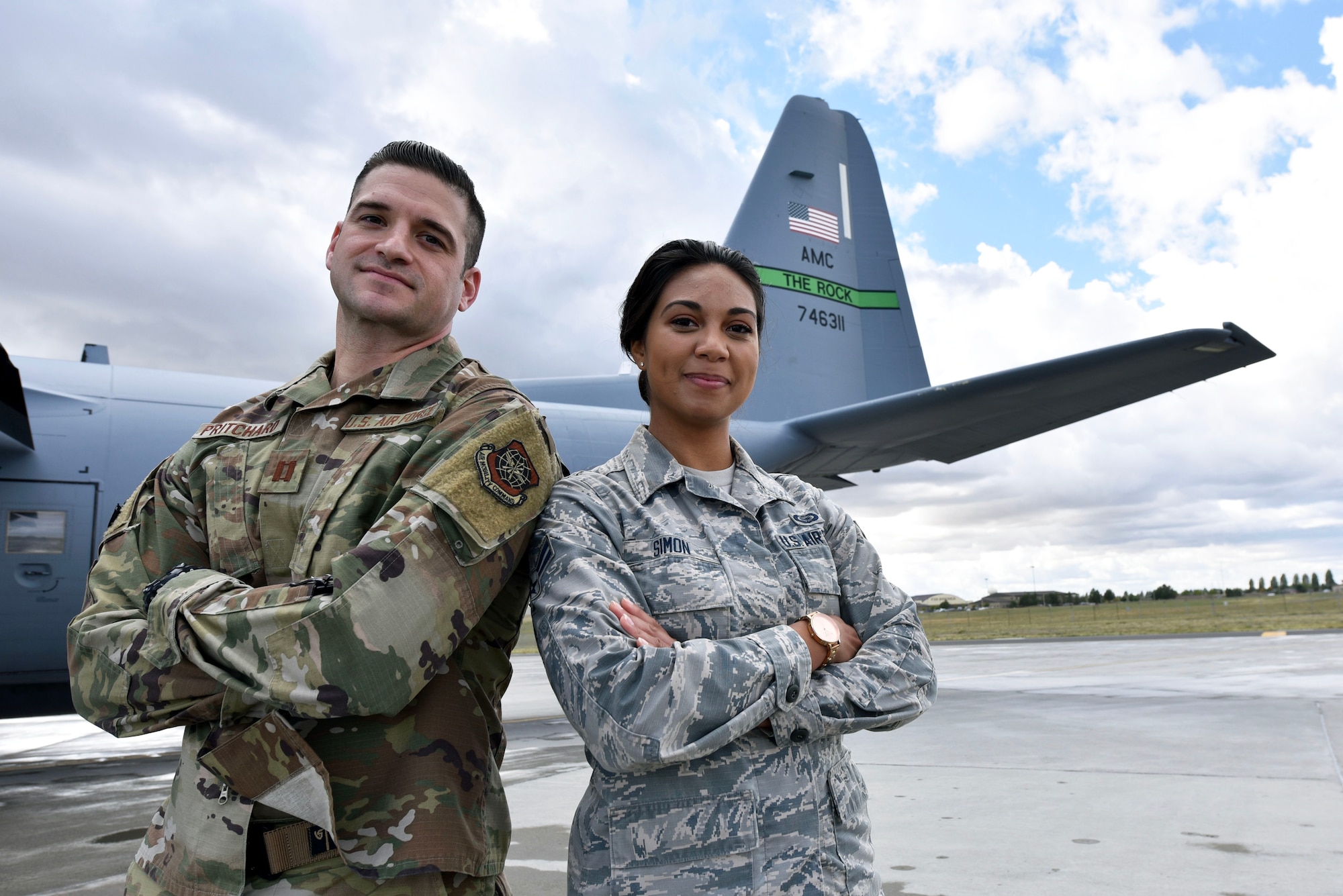 Airmen pose for a photo in front of a C-130.