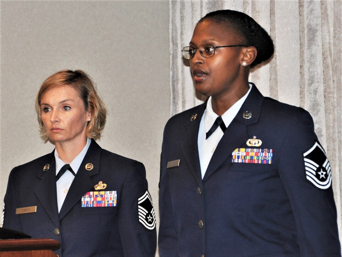 Master Sgt. Faith Wells, 340th Flying Training Group financial services section chief, sings the national anthem during the Sept. 13 retirement ceremony held at Joint Base San Antonio-Randolph, Texas for Master Sgt. Robert Sanchez, 340th Flying Training Group education and training chief, while master of ceremonies Senior Master Sgt. Laura Garcia, 340th FTG Military Personnel Section superintendent, stands at attention. (U.S. Air Force photo by Janis El Shabazz)
