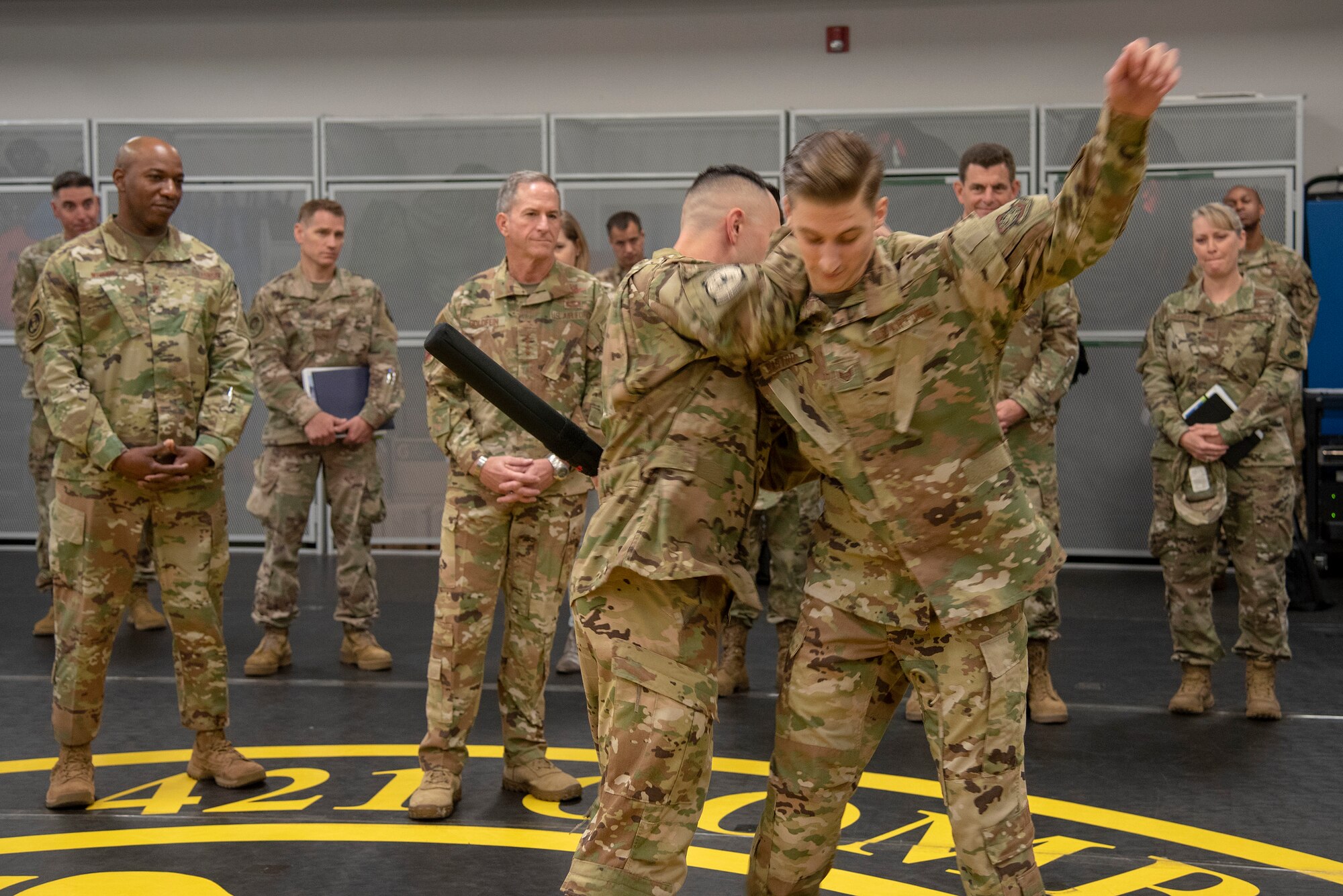 U.S. Air Force Staff Sgt. Joseph McGuire, standards and evaluations, and U.S. Air Force Staff Sgt. Brendan Bartoo, Phoenix Raven Qualification Course instructor, both assigned to the 421st Combat Training Squadron, demonstrate how to apprehend an adversary to Air Force Chief of Staff Gen. David L. Goldfein and Chief Master Sgt. of the Air Force Kaleth O. Wright during their visit to the U.S. Air Force Expeditionary Center as part of 2019 Fall Phoenix Rally, Oct. 9, 2019, at Joint Base McGuire-Dix-Lakehurst, New Jersey. Fall Phoenix Rally is a three-day summit focused on understanding leadership roles in emerging issues with Air Mobility Command, bringing together leadership and spouses from throughout the command.