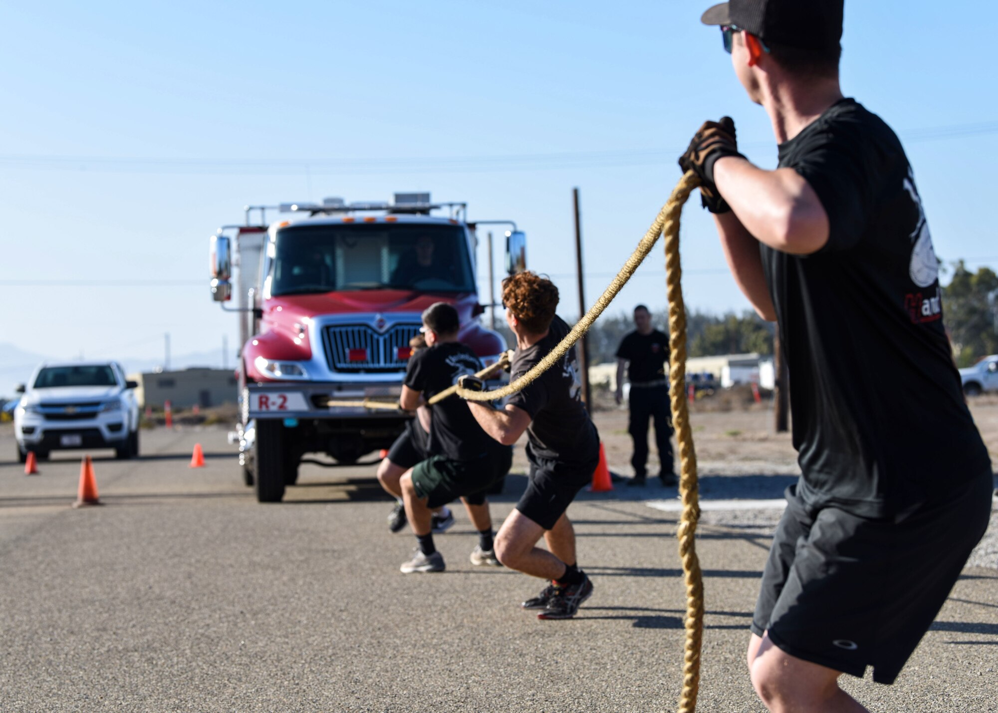 Service members pull a firetruck during the 2019 Fire Muster Challenge Oct. 10, 2019, at Vandenberg Air Force Base, Calif. Fire Prevention Week is observed annually during the week of October 9th to commemorate the Great Chicago Fire on October 8, 1871. Each year, firefighters from the installation provide lifesaving public education in an effort to drastically decrease casualties caused by fires. (U.S. Air Force photo by Airman 1st Class Aubree Milks)