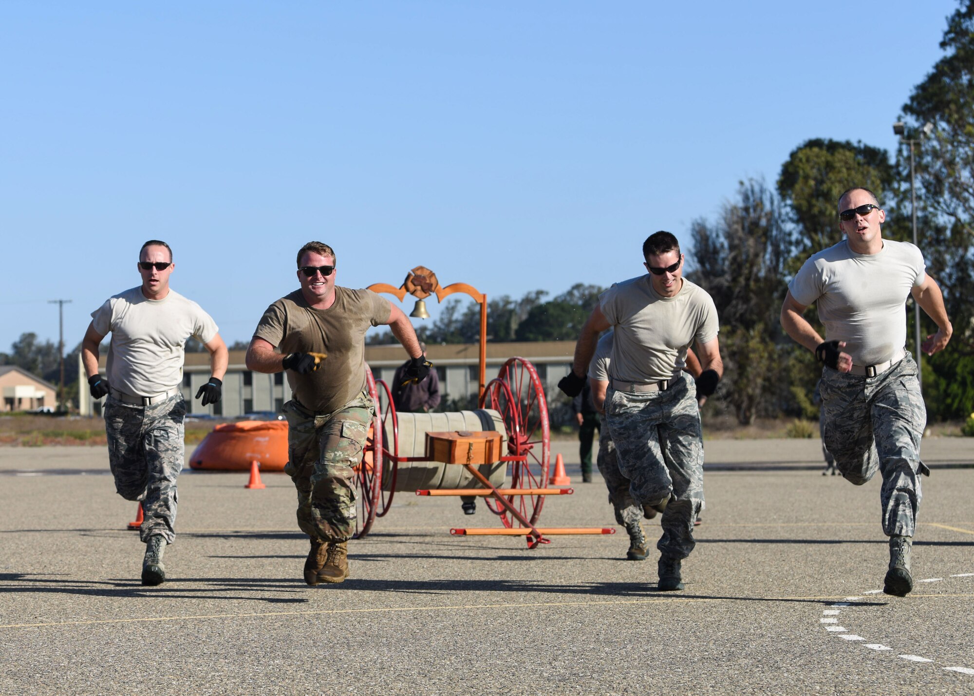 Service members run during the 2019 Fire Muster Challenge to commemorate Fire Prevention Week Oct. 10, 2019, at Vandenberg Air Force Base, Calif. During the event, five-member teams competed in the timed events to be the champion of the 2019 Fire Muster Challenge. (U.S. Air Force photo by Airman 1st Class Aubree Milks)
