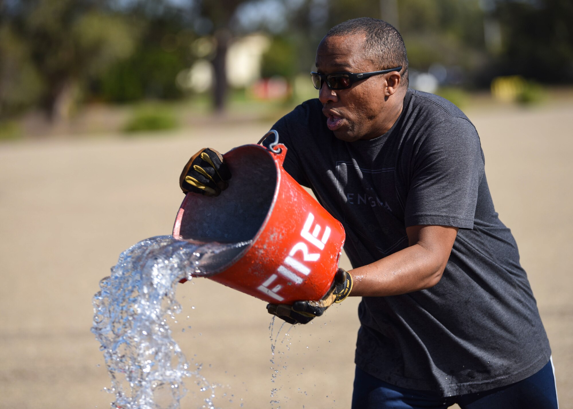 Senior Master Sgt. Curtis Brooks, 4th Space Launch Squadron superintendent, throws water in attempt to put out a house fire during the 2019 Fire Muster Challenge Oct. 10, 2019, at Vandenberg Air Force Base, Calif. More than 100 members from Vandenberg AFB gathered to participate and support this year’s Fire Prevention Week. Out of the 15 teams, a five-member group from 30th Civil Engineer Squadron won the 2019 Fire Muster Challenge. (U.S. Air Force photo by Airman 1st Class Aubree Milks)