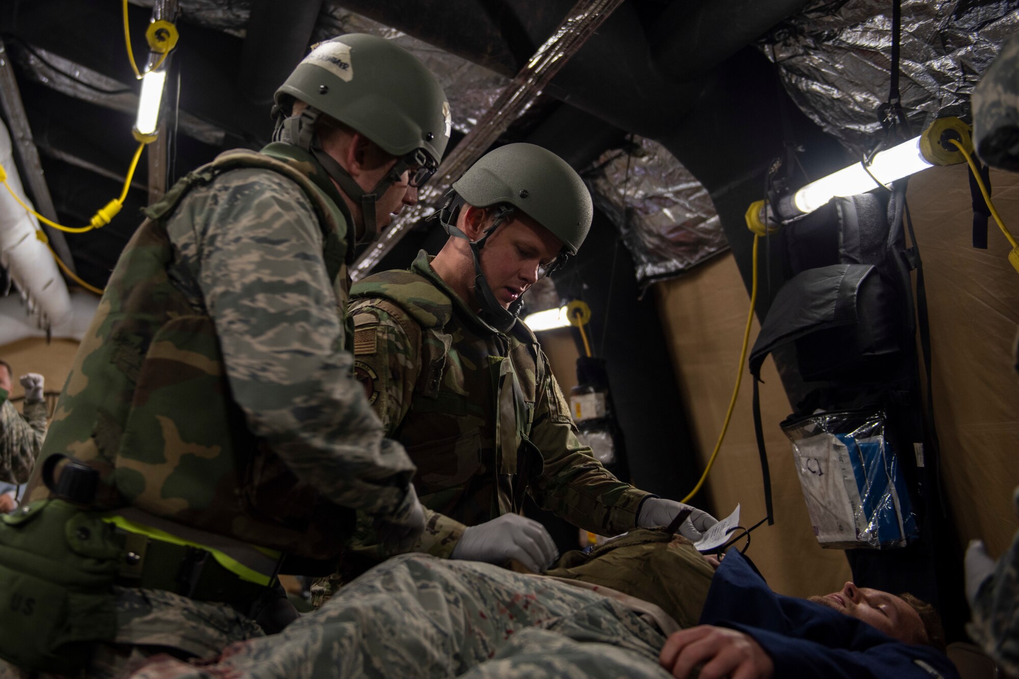 U.S. Airmen assigned to the 673d Medical Group provide Tactical Combat Casualty Care to an Airman with simulated injuries in an Expeditionary Medical Support System tent during Polar Force 20-1 at Joint Base Elmendorf-Richardson, Alaska, Oct. 8, 2019. Designed to test JBER’s mission readiness, Polar Force 20-1 is a two-week exercise that hones Airmen’s skills and experience when facing adverse situations. Airmen refined their contingency tactics, techniques and procedures in support of the Pacific Air Force’s Agile Combat Employment concept of operations. Agile Combat Support excellence yields multi-domain operations success.