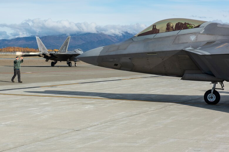 U.S. Air Force Staff Sgt. Anthony Santos, 525th Aircraft Maintenance Unit dedicated crew chief, marshalls an F-22 Raptor during an Agile Combat Employment (ACE) aircraft refueling exercise as part of a Polar Force 20-1 training and mission readiness exercise at Joint Base Elmendorf-Richardson, Alaska, Oct. 3, 2019. Polar Force 20-1 is designed to exercise multiple elements of the ACE concept of operations. These elements include generating fifth-generation combat power from austere locations, command and control using non-traditional methods, and rapid airlift capabilities to sustain a forward operating location. The ACE concept enables the 3rd Wing to deliver lethal airpower for the United States, even in a contested environment.
