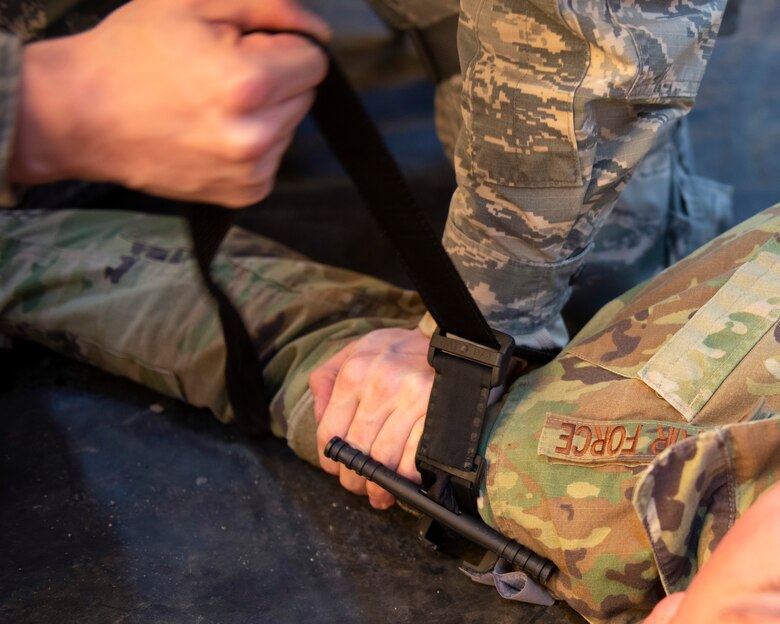 U.S. Air Force Senior Airman Draven Graves, 773rd Logistics Readiness Squadron household goods technician, applies a tourniquet to U.S. Air Force Senior Airman James Poe, 773rd LRS outbound cargo technician, during a Tactical Combat Casualty Care course during Polar Force 20-1 at Joint Base Elmendorf-Richardson, Alaska, Oct. 7, 2019. Designed to test JBER’s mission readiness, Polar Force 20-1 is a two-week exercise that hones Airmen’s skills and experience when facing adverse situations. Airmen refined their contingency tactics, techniques and procedures in support of the Pacific Air Force’s Agile Combat Employment concept of operations. Agile Combat Support excellence yields multi-domain operations success.