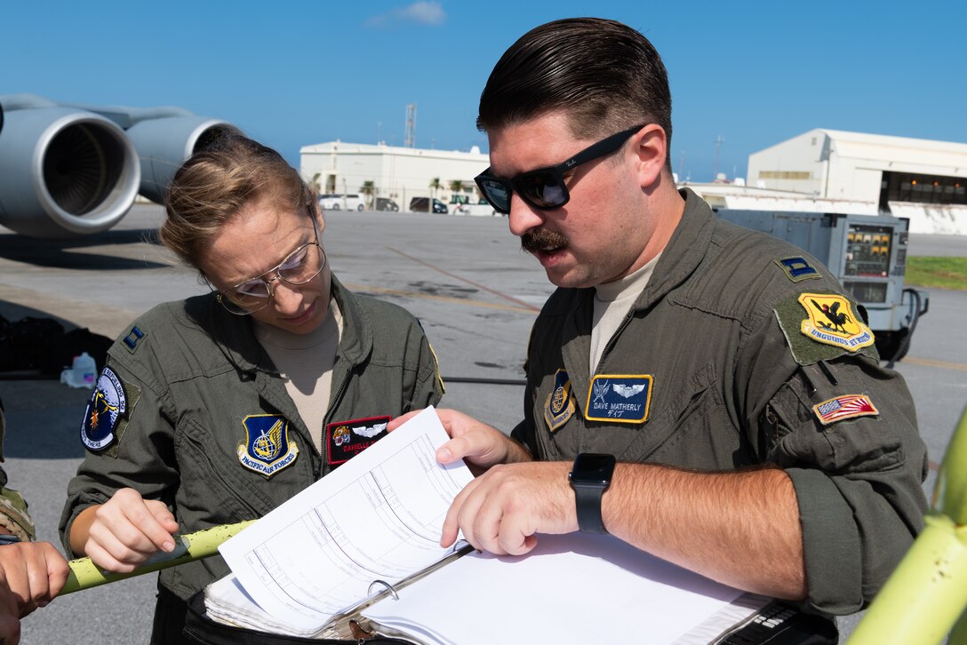 U.S. Air Force Capt. Danielle Rivera and U.S. Air Force Capt. Dave Matherly, pilots assigned to the 909th Air Refueling Squadron, review pre-flight requirements Oct. 4, 2019, at Kadena Air Base, Japan. The 909th ARS enables the execution of tactical, conventional, and peacetime operations in the Indo-Asia Pacific region. (U.S. Air Force photo by Senior Airman Cynthia Belío)